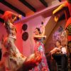 A flamenco club with dancers and guitarist.