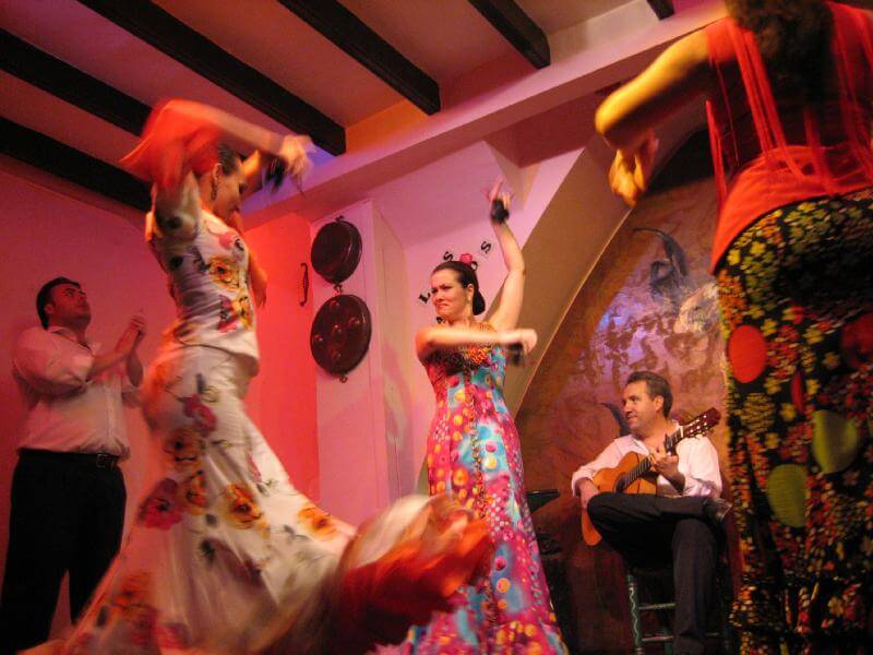 A flamenco club with dancers and guitarist.