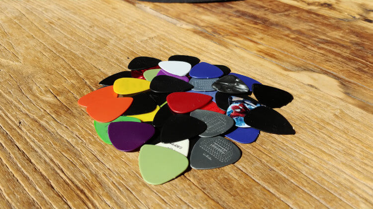A range of guitar picks with different thicknesses, which affects the tone of the guitar.