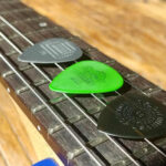 Delrin Tortex and Nylon picks on an electric guitar neck.
