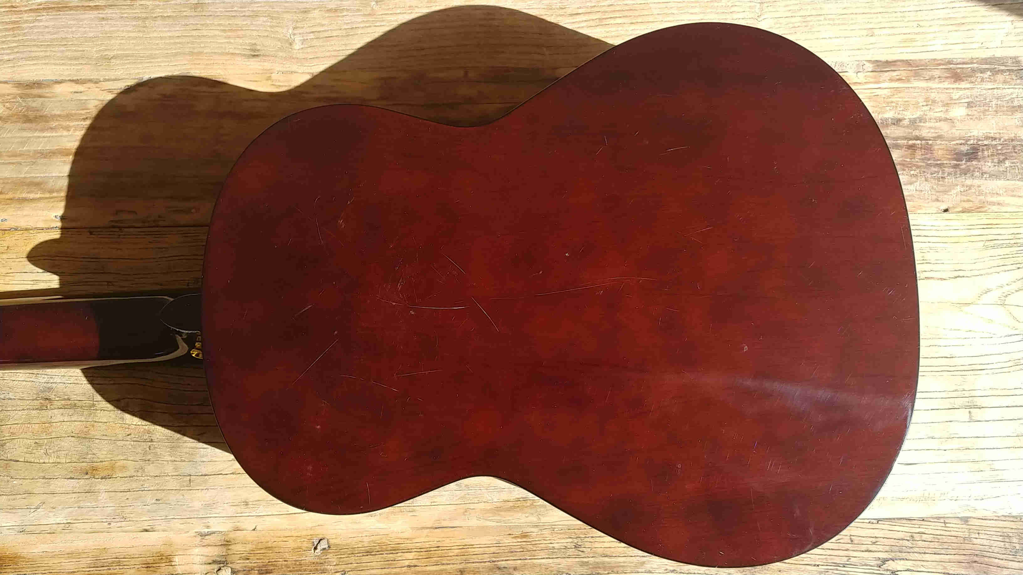 The back of the Artist CL44AM guitar with scratches.