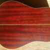The mahogany back and sides of an Epiphone Masterbilt R-500MNS acoustic guitar.